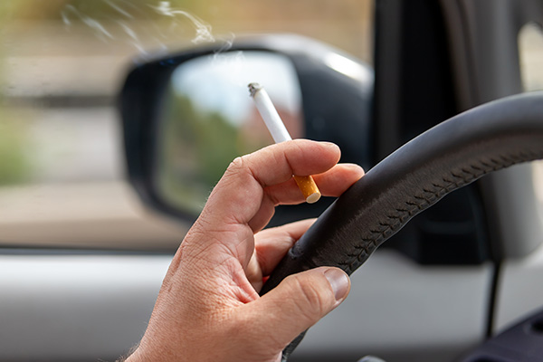 Raucherauto: Zigarrete in der Hand am Lenkrad